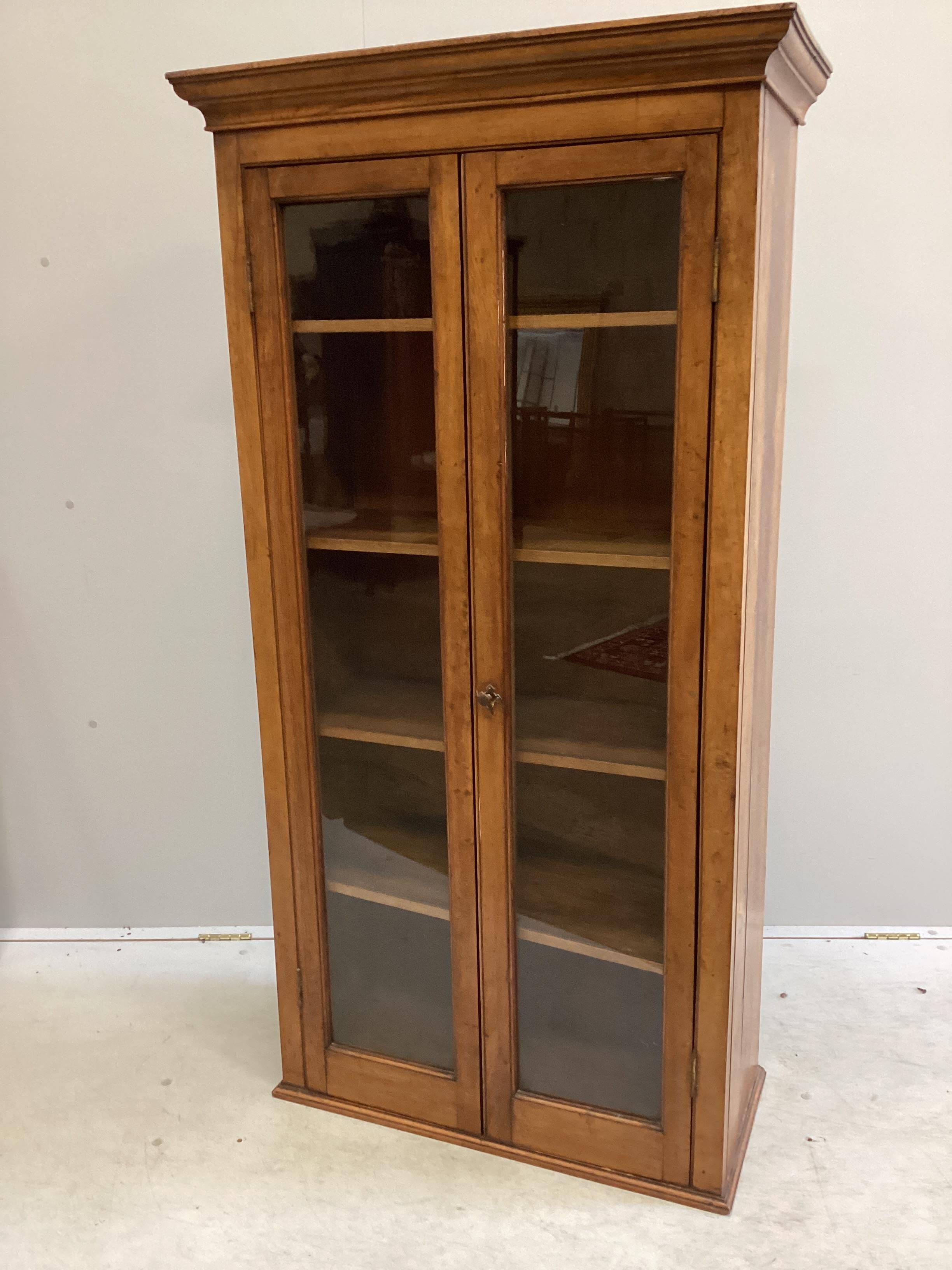 An early 20th century oak and mahogany narrow bookcase with later plinth foot, width 78cm, depth 36cm, height 153cm